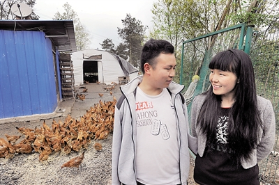 ?吴晓凡和妻子吴金平在自家养鸡场聊天。本报记者 李斌 摄